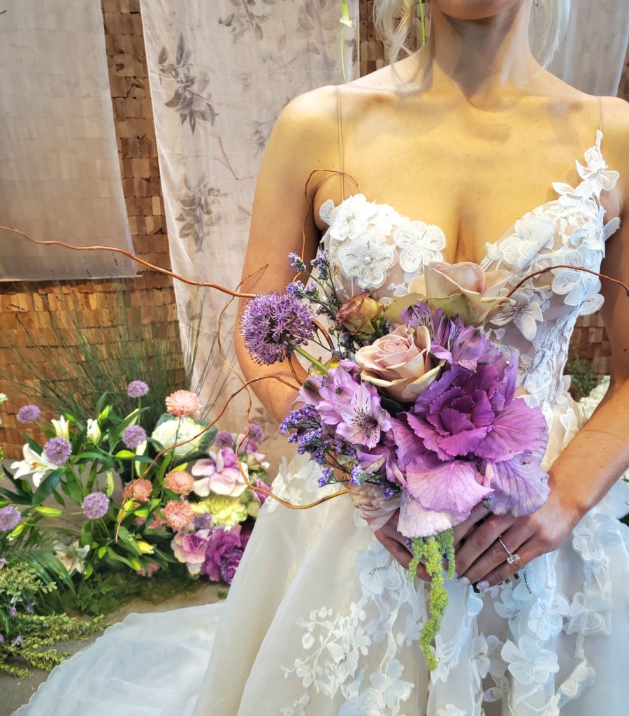 Bride holding a purple bouquet. 